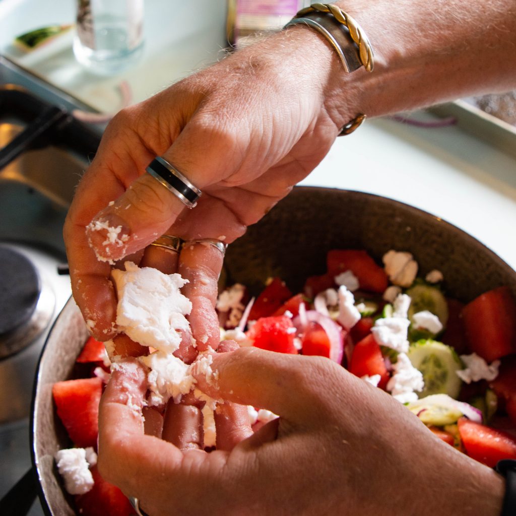 Image features a watermelon and feta salad being tossed